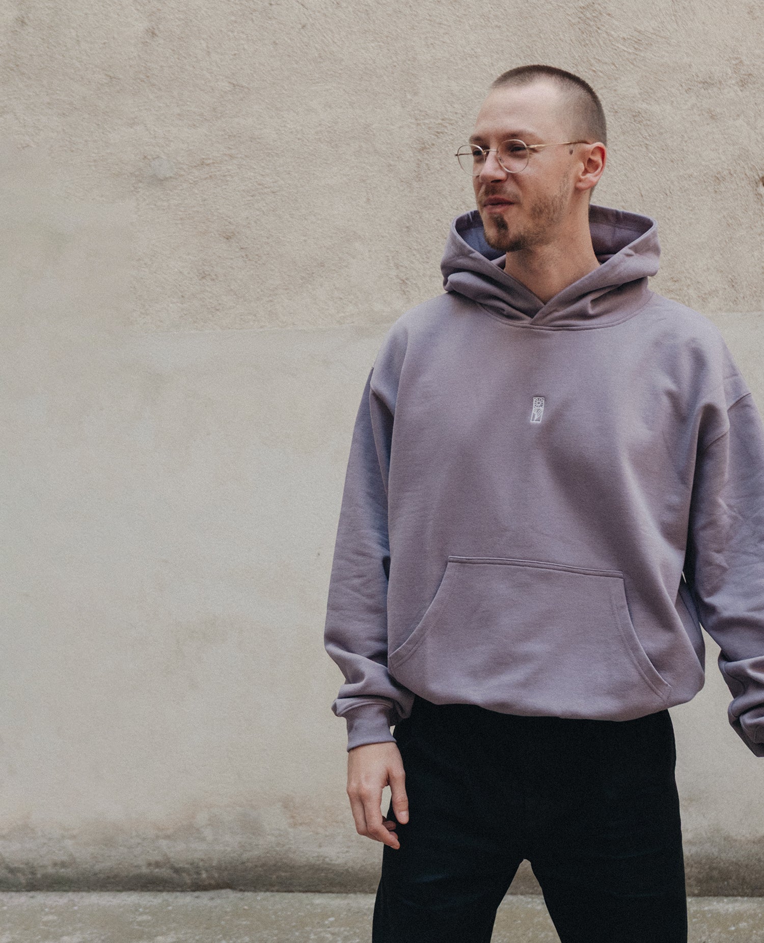 Blume Hoodie Lila von NKSP – am Model mit Kängurutasche